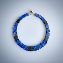 Load image into Gallery viewer, Necklace with blue and black square beads on a light gray background