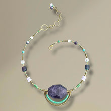 Load image into Gallery viewer, Necklace with purple stone and multicolored beads on a beige background