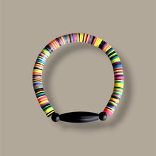 Load image into Gallery viewer, A colorful beaded collar necklace with a black wooden toggle clasp, displayed on a solid taupe background.