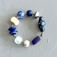 Load image into Gallery viewer, Bracelet with blue, white, and silver beads on a light gray background