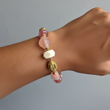 Load image into Gallery viewer, Bracelet with pink and gold beads on a wrist against a gray background