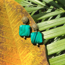 Load image into Gallery viewer, Green square earrings with gold accents on a leaf