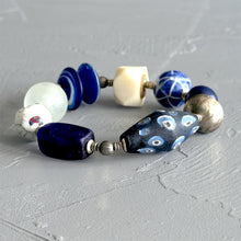 Load image into Gallery viewer, Beaded bracelet with blue, white, and silver beads on a gray surface