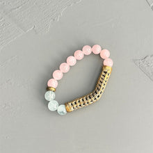 Load image into Gallery viewer, Bracelet with rose quartz and aquamarine beads with a brass accent on a gray background.