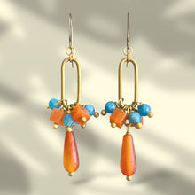 Load image into Gallery viewer, Gold earrings with colorful beads on a gradient background