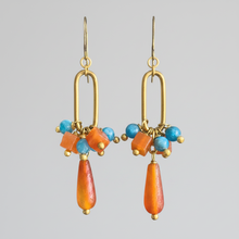 Load image into Gallery viewer, orange and teal dangle earrings on a gray background