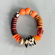 Load image into Gallery viewer, Orange Multicolored African beaded bracelet on a gray textured surface