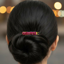 Load image into Gallery viewer, A close-up back view of a person with dark hair styled in a low bun, secured with a small ruby hair barrette with brass ends, against a simple background.