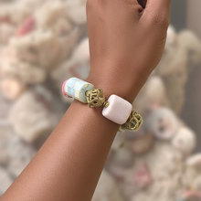 Load image into Gallery viewer, Bracelet with pink and gold elements on a wrist against a blurred natural background