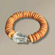Load image into Gallery viewer, Bracelet with brown circular beads and a large pale green gemstone on a beige background