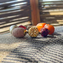 Load image into Gallery viewer, Set of colorful buttons on a textured surface with a blurred background