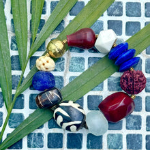 Load image into Gallery viewer, Colorful beaded bracelet on a green leaf with a blue tiled background