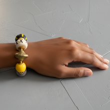Load image into Gallery viewer, Hand wearing a yellow, black, and cream bracelet on a gray surface