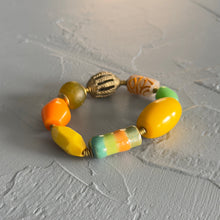 Load image into Gallery viewer, Citrus colored beaded bracelet on a textured gray surface
