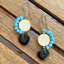 Load image into Gallery viewer, Pair of earrings with turquoise beads and black circular stones on a wooden surface