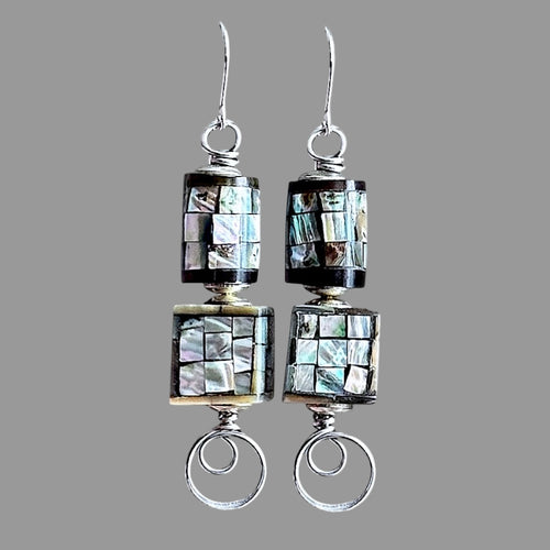 Pair of silver earrings with mosaic pattern on a gray background