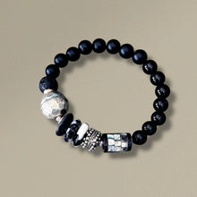 Load image into Gallery viewer, Black beaded bracelet with silver and metallic beads on a beige background