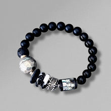 Load image into Gallery viewer, Black beaded bracelet with silver and white beads on a gray background