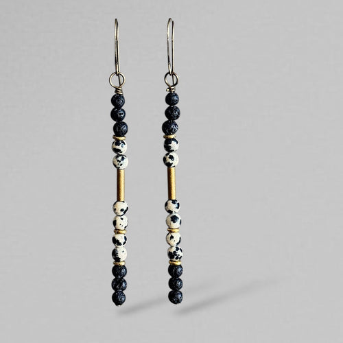 Pair of Dalmatian jasper matchstick beaded earrings on a gray background