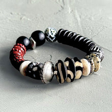 Load image into Gallery viewer, Dark neutral African multicolored beaded bracelet on a light gray background