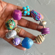 Load image into Gallery viewer, Colorful beaded bracelet held in a hand against a neutral background