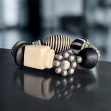 Load image into Gallery viewer, Set of black, white, and beige bracelets on a reflective surface with a blurred background