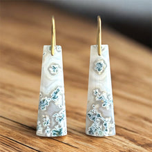 Load image into Gallery viewer, Tall, white and  green earrings with gold hooks on a wooden surface