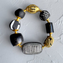 Load image into Gallery viewer, Bracelet with black, gold, and silver beads on a light gray background