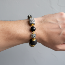 Load image into Gallery viewer, black and white bracelet being worn in a wrist against a gray background