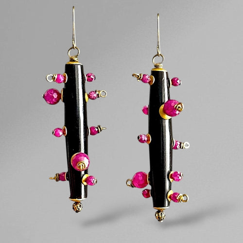 black and pink earrings on a grey background