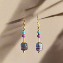 Load image into Gallery viewer, Pair of earrings with turquoise, lavender and pool blue beads on a beige background