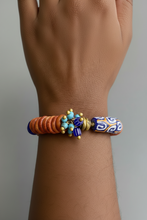 Load image into Gallery viewer, Multicolored beaded bracelet on a wrist against a neutral background